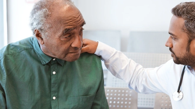 Doctor consoling male patient